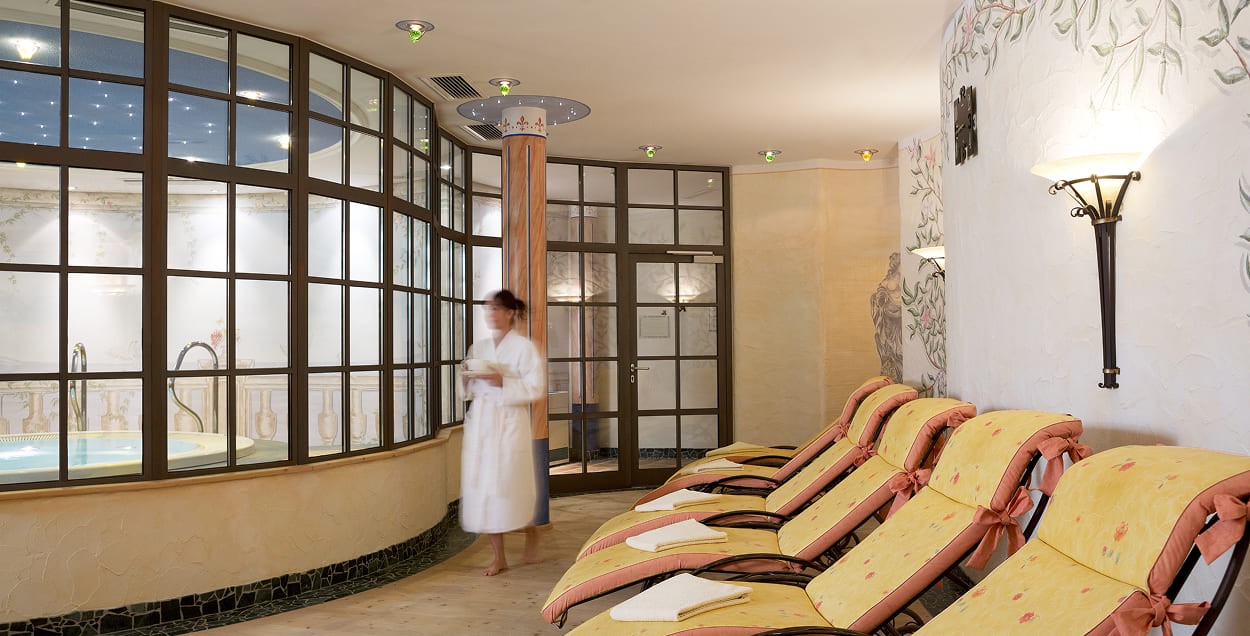 Frau geht durch den Ruheraum des Auhof Wellnessbereichs