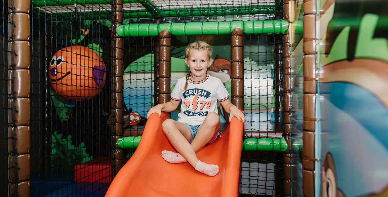 Mädchen rutsch im Auhof Indoor Spielplatz
