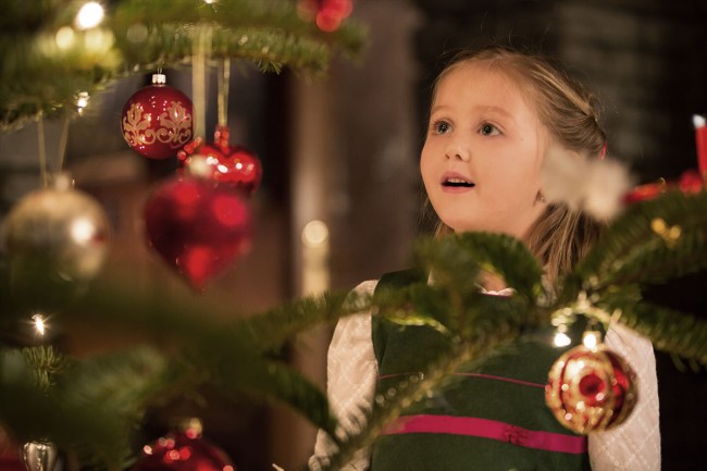 Strahlendes Kind vor einem Christbaum © SalzburgerLand Tourismus