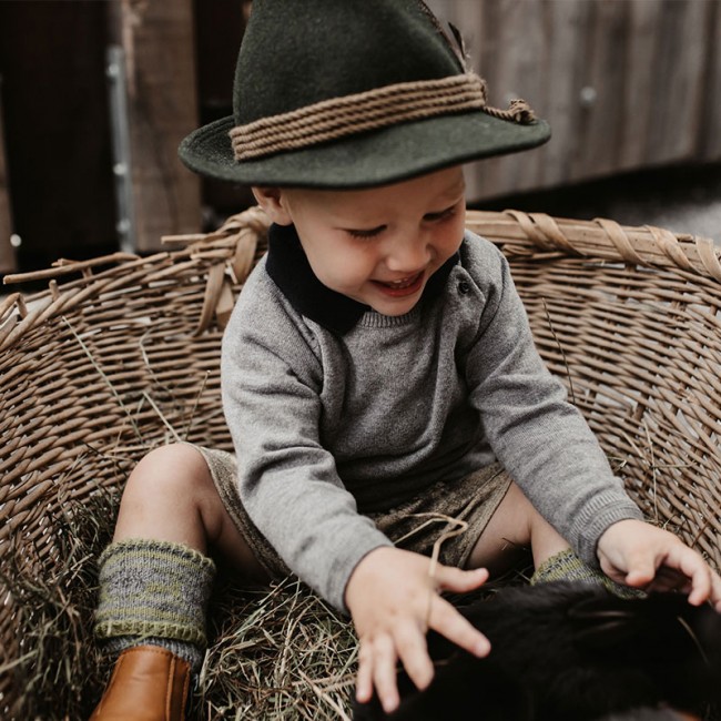 Kleinkind streichelt Babyhasen
