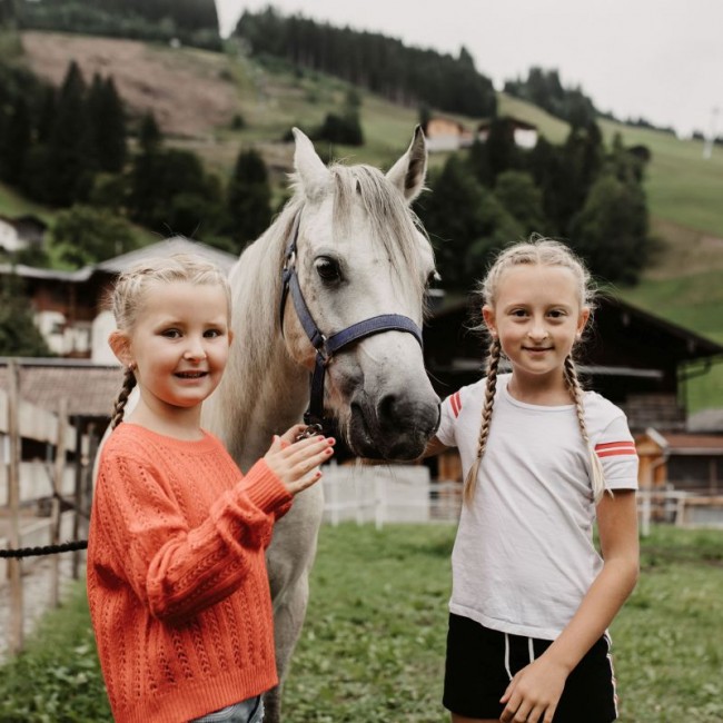 Two children with a horse at the petting zoo at Hotel Auhof in Gro&szlig;arl
