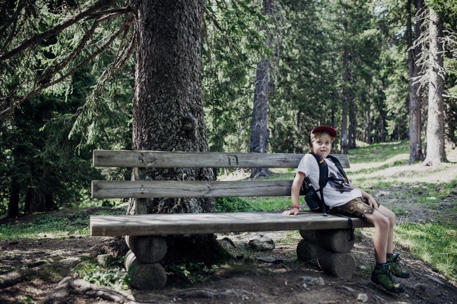 Junge rastet auf einer Bank im Wald © FNPHT